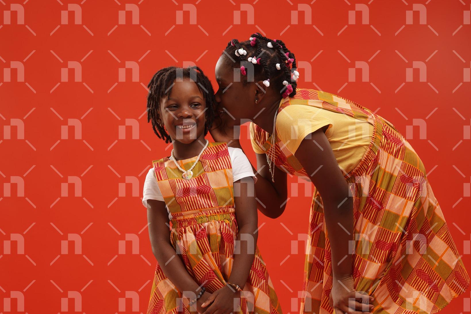 deux-fillettes-agees-dentre-5-et-10-ans-vetues-en-tenues-de-ville-faites-de-pagne-traditionnel-mijotant-quelque-chose-avec-le-sourire