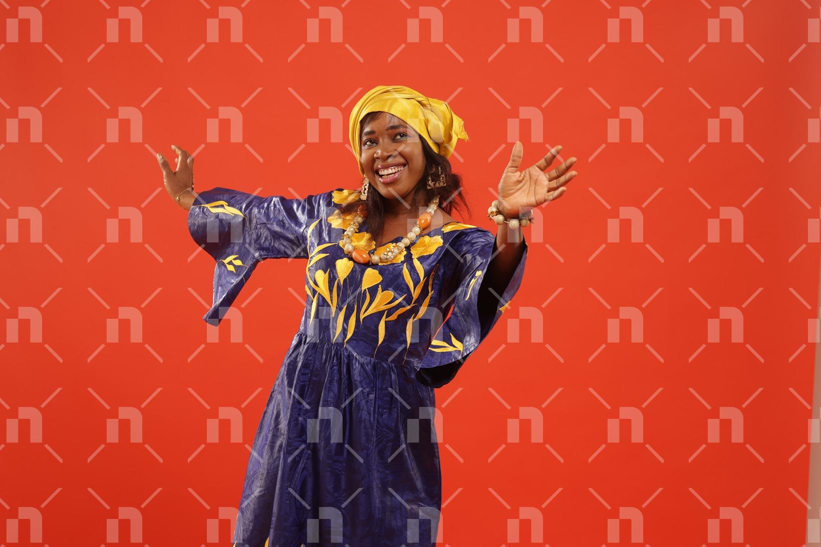 vetue-dun-boubou-africain-fait-a-base-de-bazin-de-couleur-violette-cette-femme-danse-avec-un-beau-sourire-pour-une-photo-studio