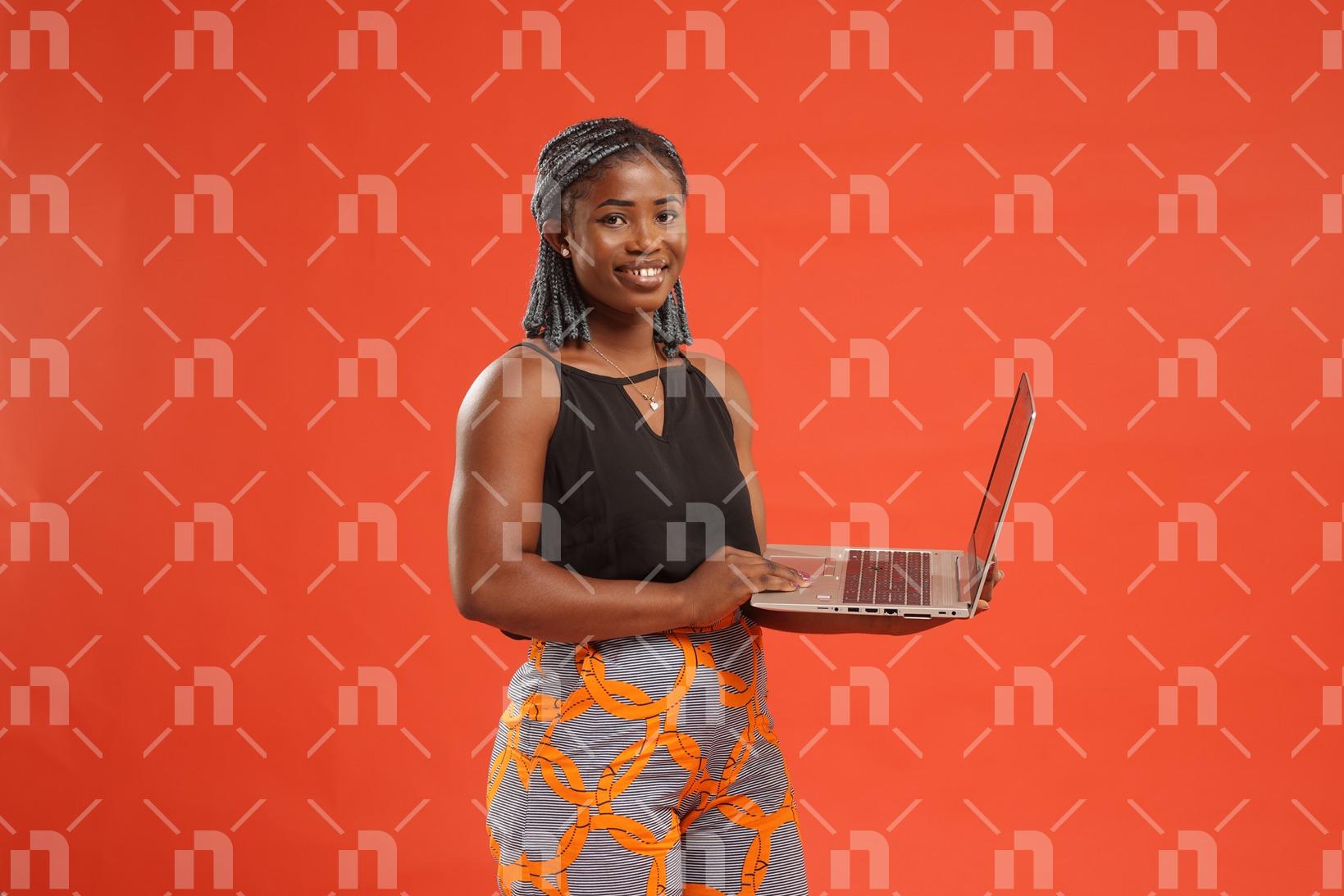 jeune-femme-africaine-tenant-un-ordinateur-portable-en-main-avec-le-sourire-pour-une-photo-studio