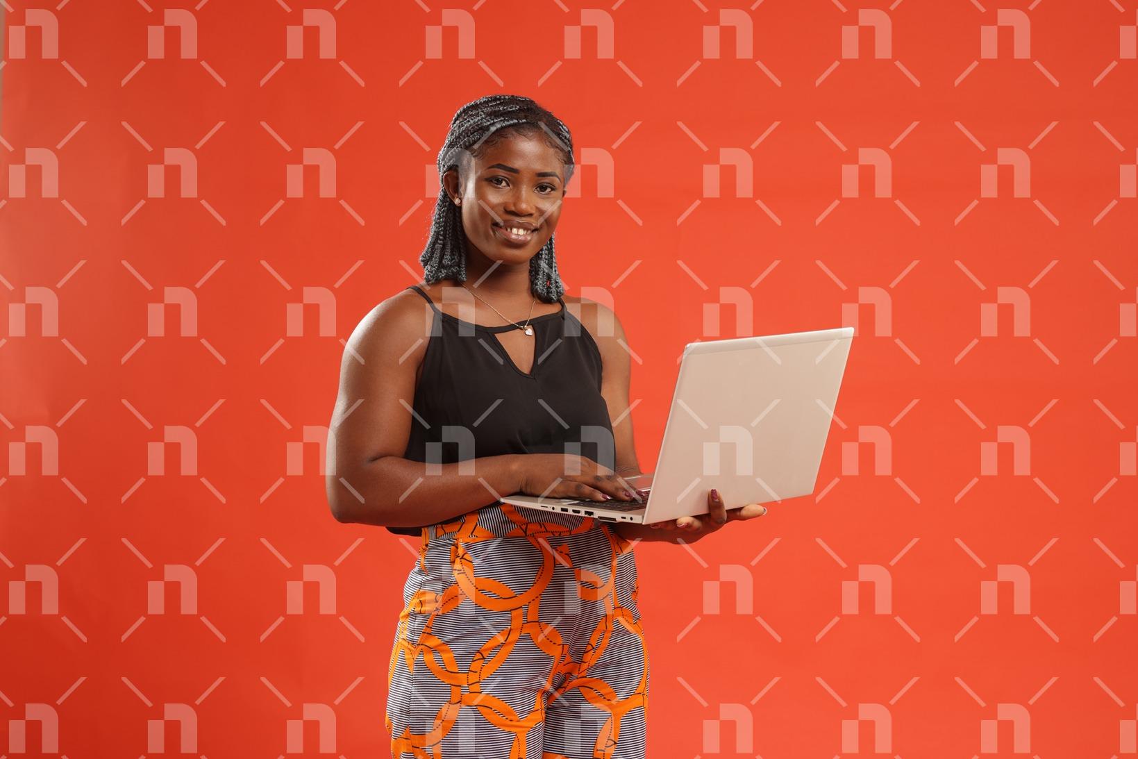 jeune-fille-africaine-moderne-posant-fierement-avec-un-ordinateur-portable-avec-un-grand-sourire