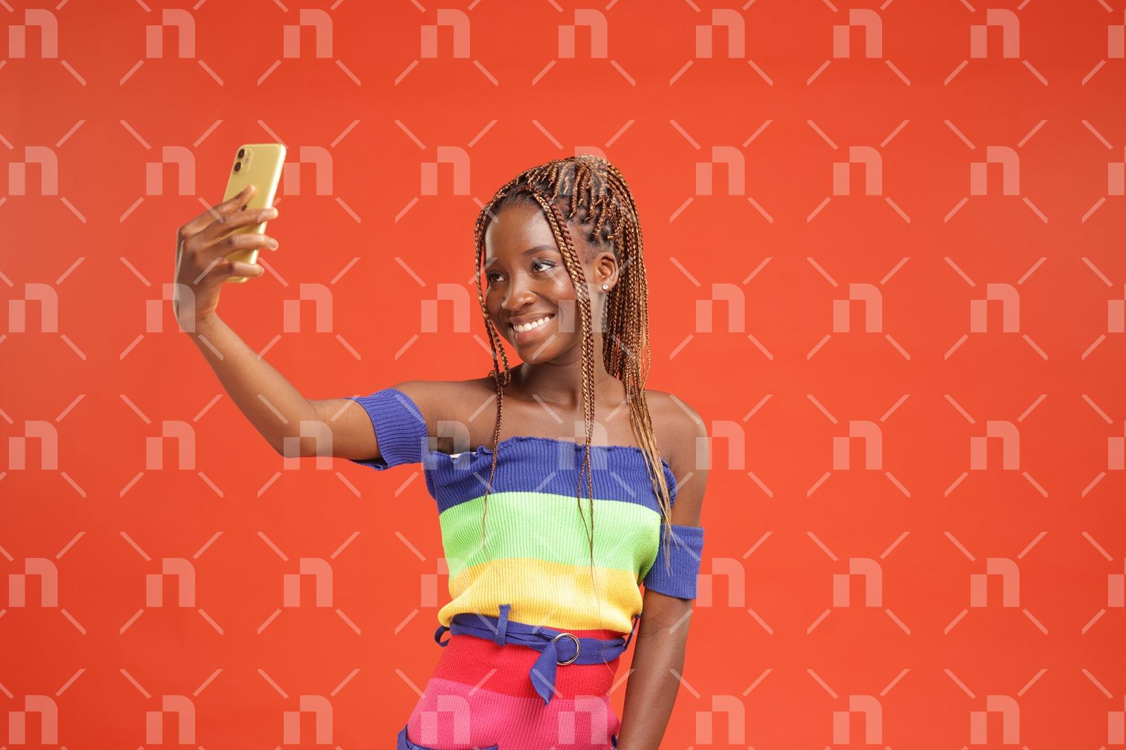 avec-un-sourire-voyageur-une-jeune-fille-africaine-moderne-pose-devant-son-telephone-portable-avec-le-sourire-pour-une-photo-studio