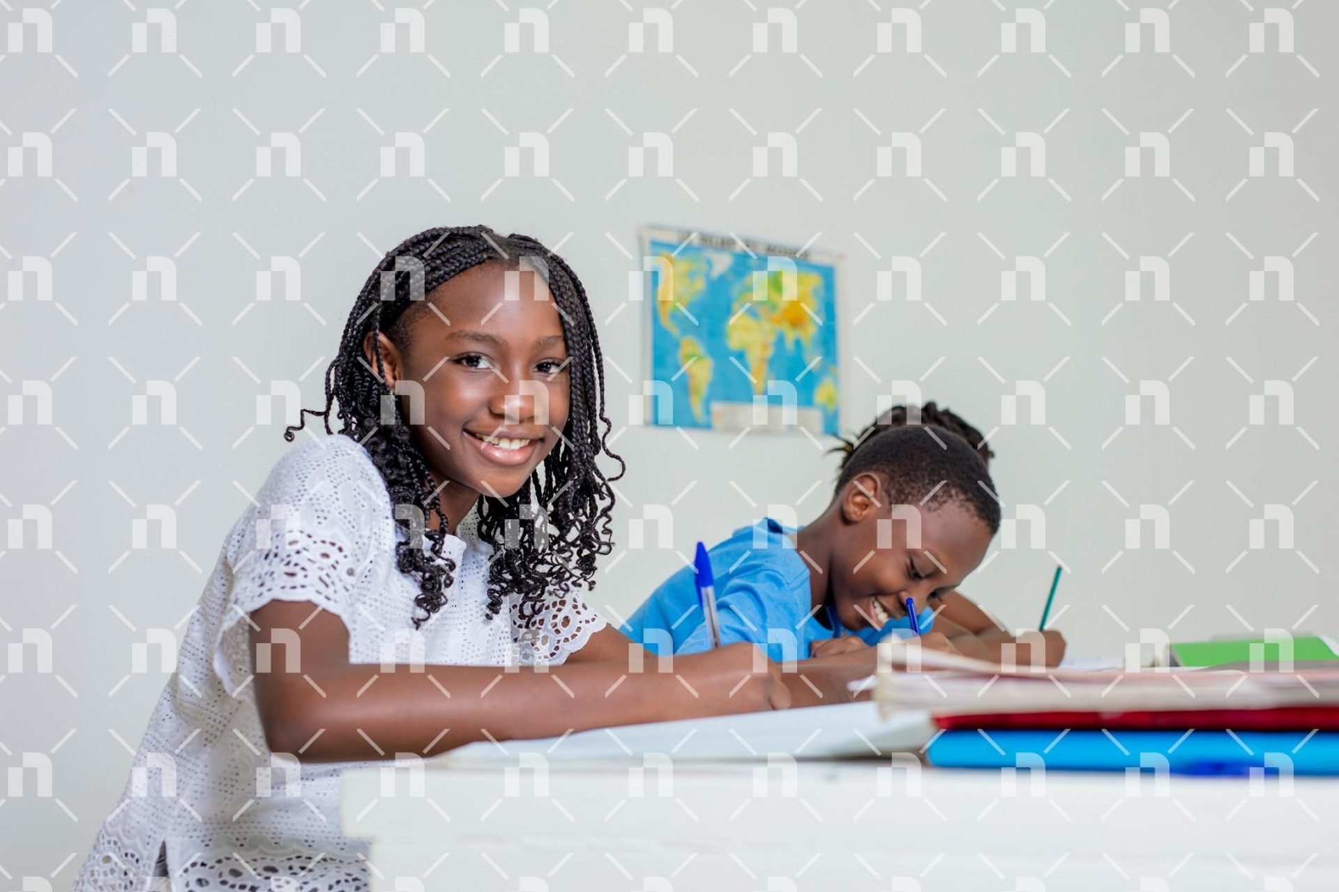 trois-enfants-africains-assis-en-salle-de-classe-ecrivant-joyeusement-dans-des-cahiers