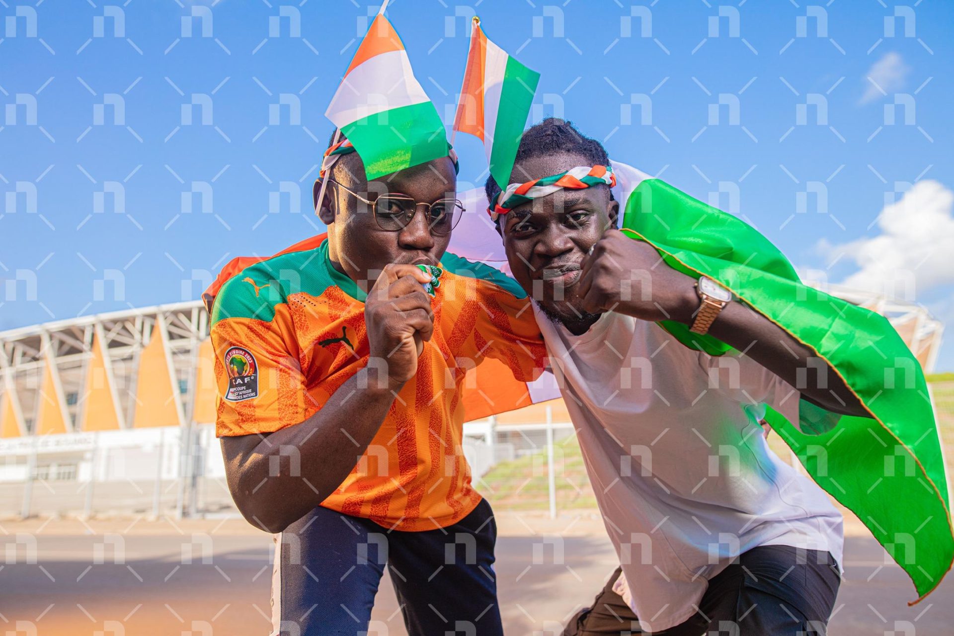 supporteurs-ivoiriens-avec-des-bandeaux-sur-la-tete-derriere-le-stade-dont-un-donne-un-baise-au-maillot